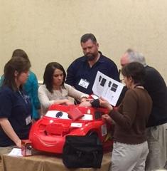 Cassie Swinehart (OTD alumna), Emily McLaerren (OT student), and faculty instruct Go Baby Go course participants in modifying a ride-on car.