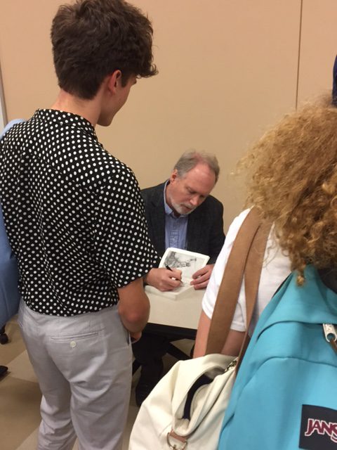 Dr. Harrington signing a student's copy of his book