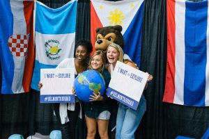 Students at the Study Abroad Fair holding signs of the places they want to travel to