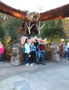 Estelle, Verona, Olivia and Ivy standing in front of a Dollywood sign