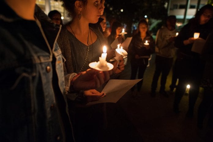 Students hold candles at a previous MLK Day candlelight vigil on campus