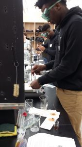 A high school student performs a science experiment on Belmont's campus.