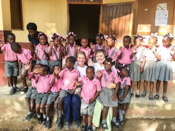 Whitwell and Beggs surrounded by children in Haiti