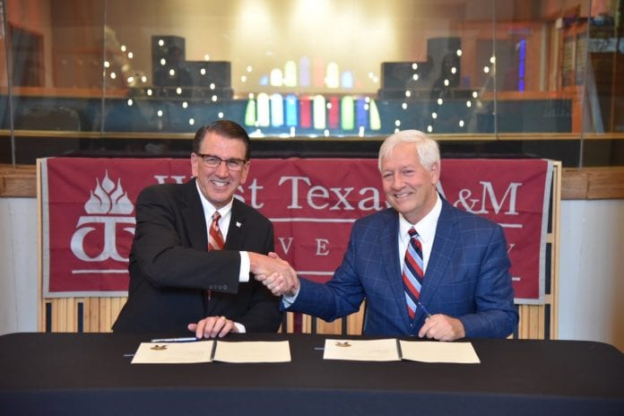 Both University presidents shake hands after signing the agreement between West Texas and Belmont.