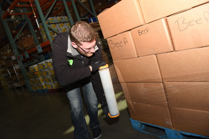 A staff member wraps a pallet with plastic wrap--ready for shipment!