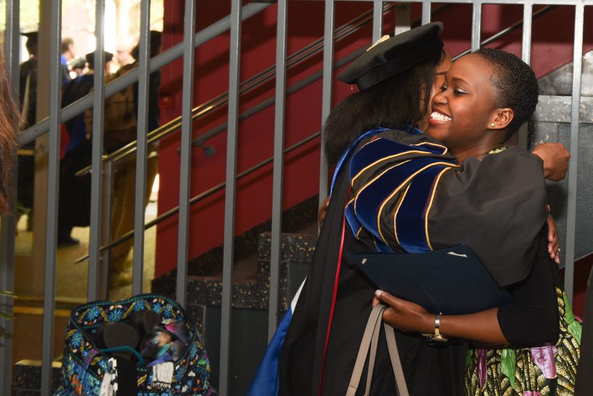 A student hugs a faculty member following awards day
