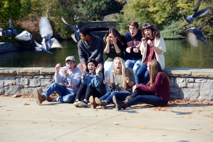 A group of students are 'photobombed' during an Admissions shoot at Centennial Park