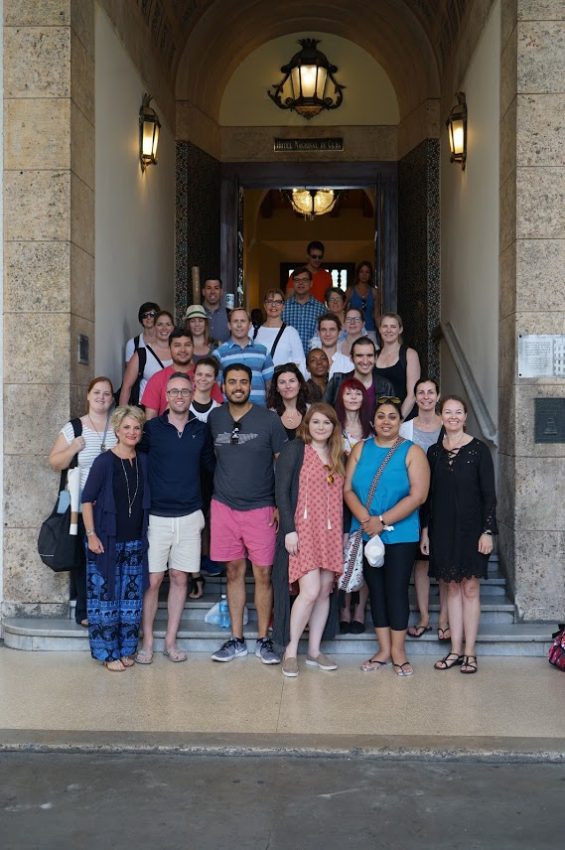 The Massey Alumni trip to Cuba participants pose in front of a historical building.