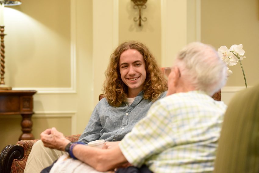 A second students sits and interviews one of the residents. 