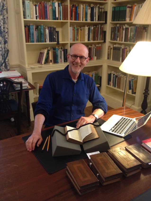 Dr. Douglas Murray poses with a collection of books inside Chawton