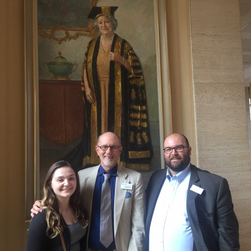  The three Belmont speakers stand in the Senate House of the University, in front of a portrait of the University's previous Chancellor, Queen Elizabeth, the Queen Mother.  