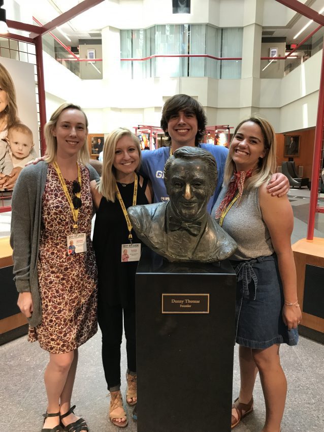 Students stand with a bust of Danny Thomas at St. Jude