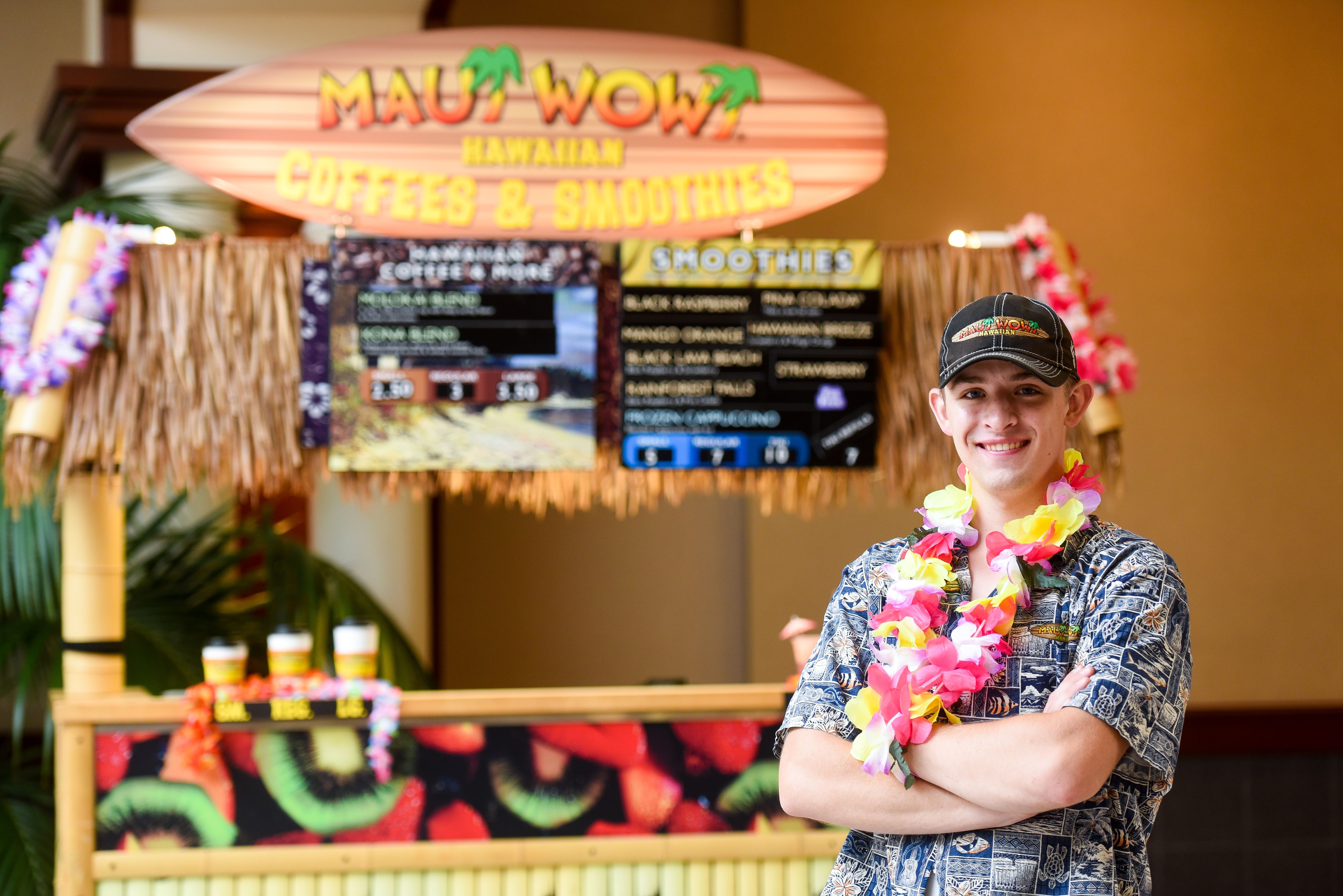 Nathan Fink stands in front of his Maui Wowie stand on belmont's campus,.