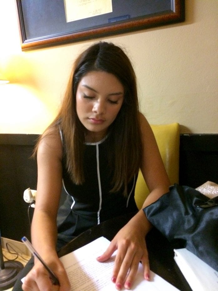 Crystal Lemus writing at a desk