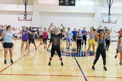 Students doing jumping jacks in the rec center gym