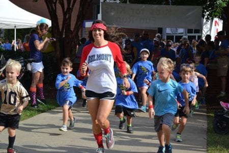 A Belmont DPT student runs alongside children who are participating in the Fun Run. 