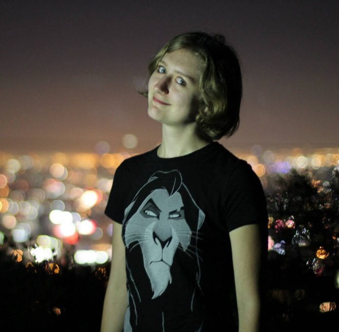 Bethany Brinton smiling in front of a cityscape at night