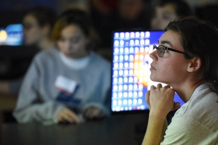 A student watches a presentation at the Women in Science Symposium