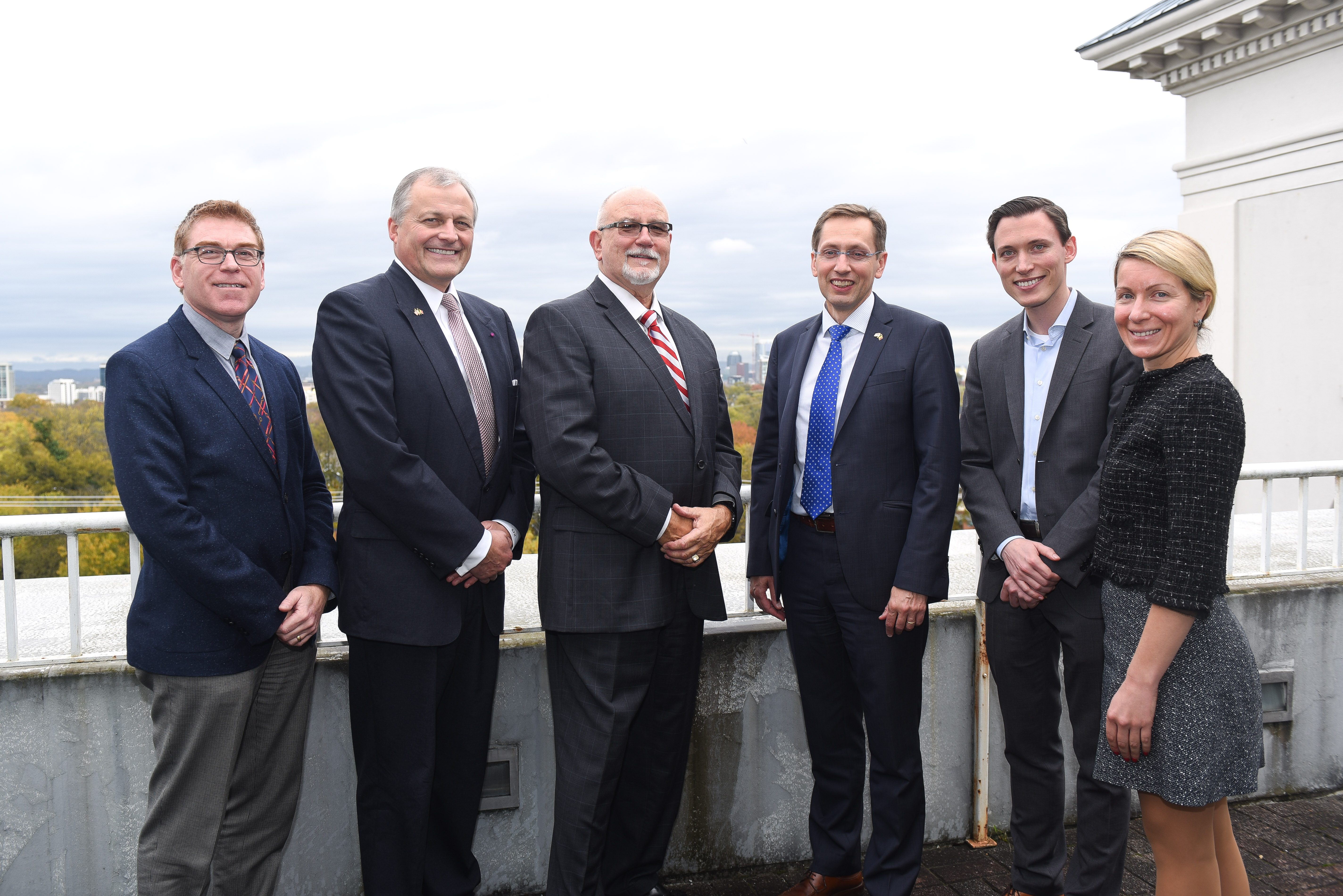 A group of Massey faculty standing on a balcony with the consulate of Belgium