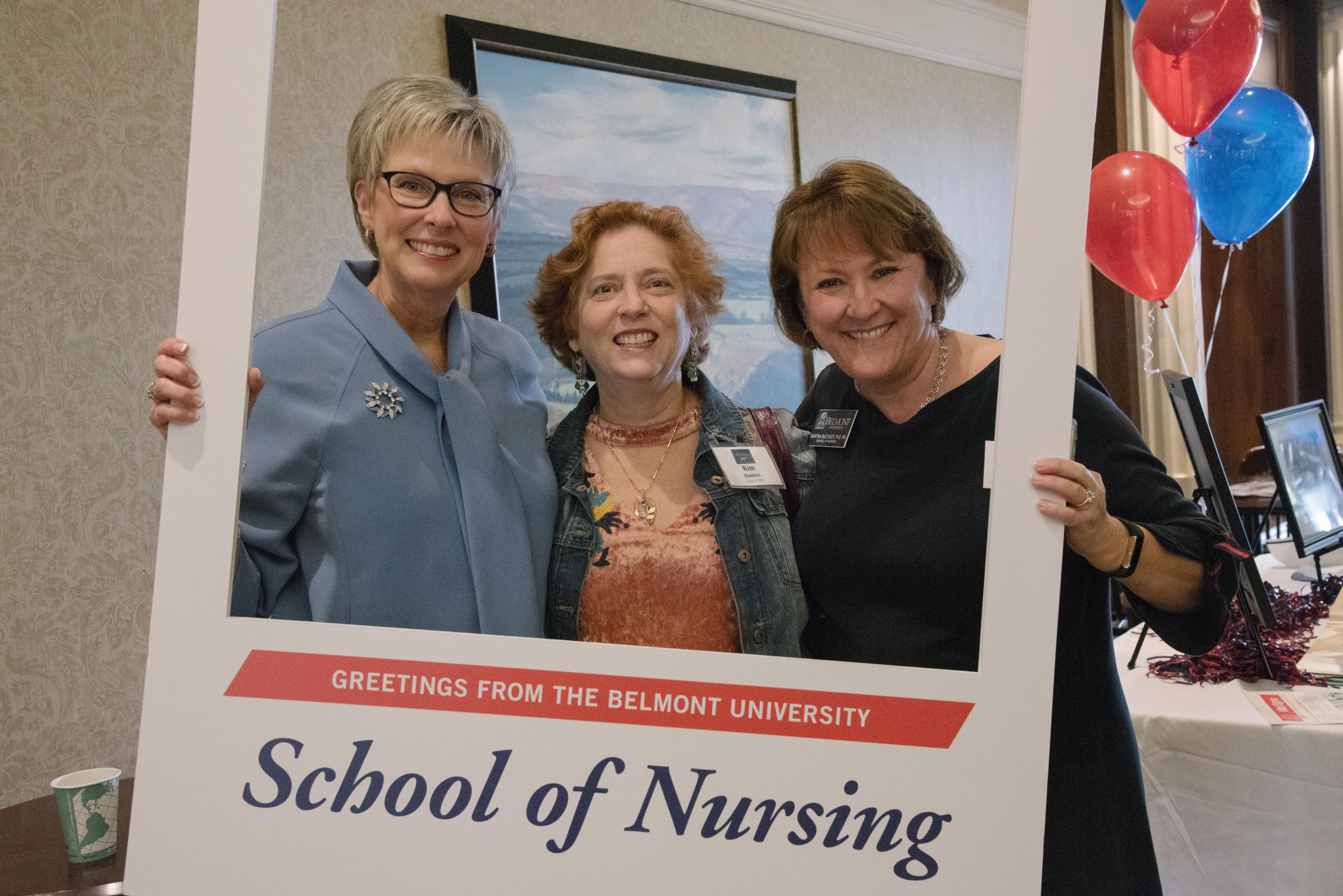 Dean Taylor and two other faculty members pose with the School of Nursing photo frame at the School's 45th anniversary celebration.