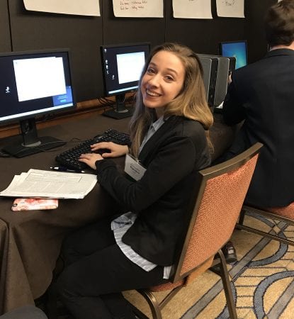 Aubrey Keller sitting at a computer, smiling