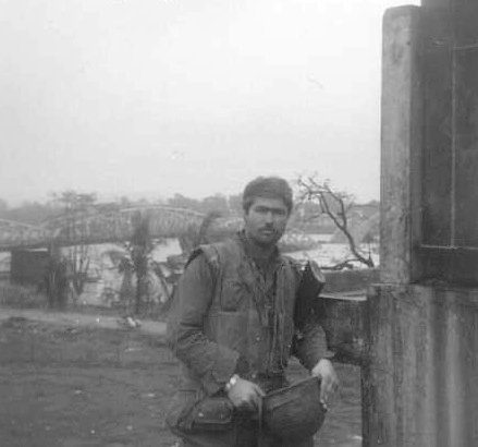 Tome Mitchell standing in front of a lake in Vietnam in the '60's