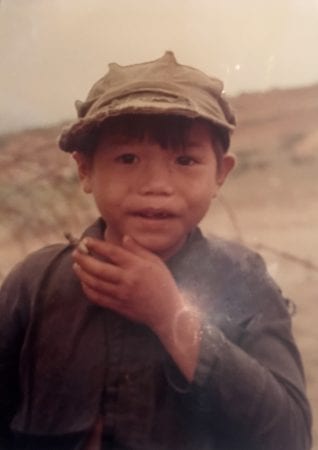 Young Vietnamese boy, frowning at the camera