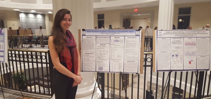 Hope Kramer, standing beside her research posters