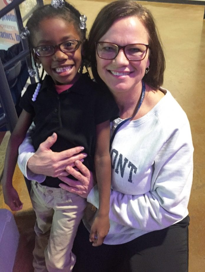 Joy Kimmons smiling with young student