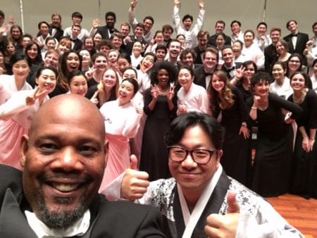 Ames (left) and Park (right) pose for a photo in front of members of both their choirs