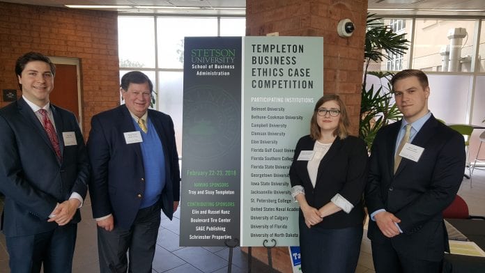 the ethics team standing next to a sign for the competition