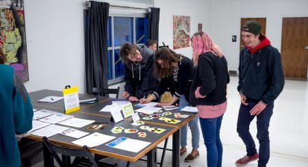 group standing around a table, writing letters