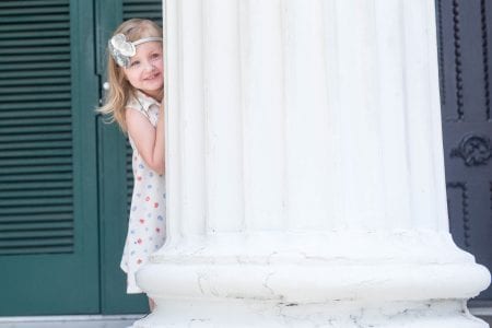 Zoe Tyrney pops out from behind a column on Belmont's campus during a photo shoot.