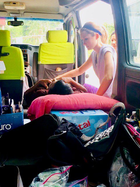 A FNP student examines a Cambodian patient in the back of her van -- getting creative with the resources she was given while on Maymester in Cambodia.