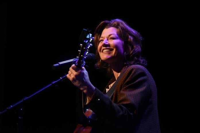 Amy Grant holds her guitar as she stands on stage during chapel at Belmont University.