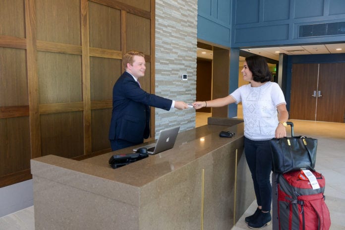 Two Students Shake Hands in Hotel Setting