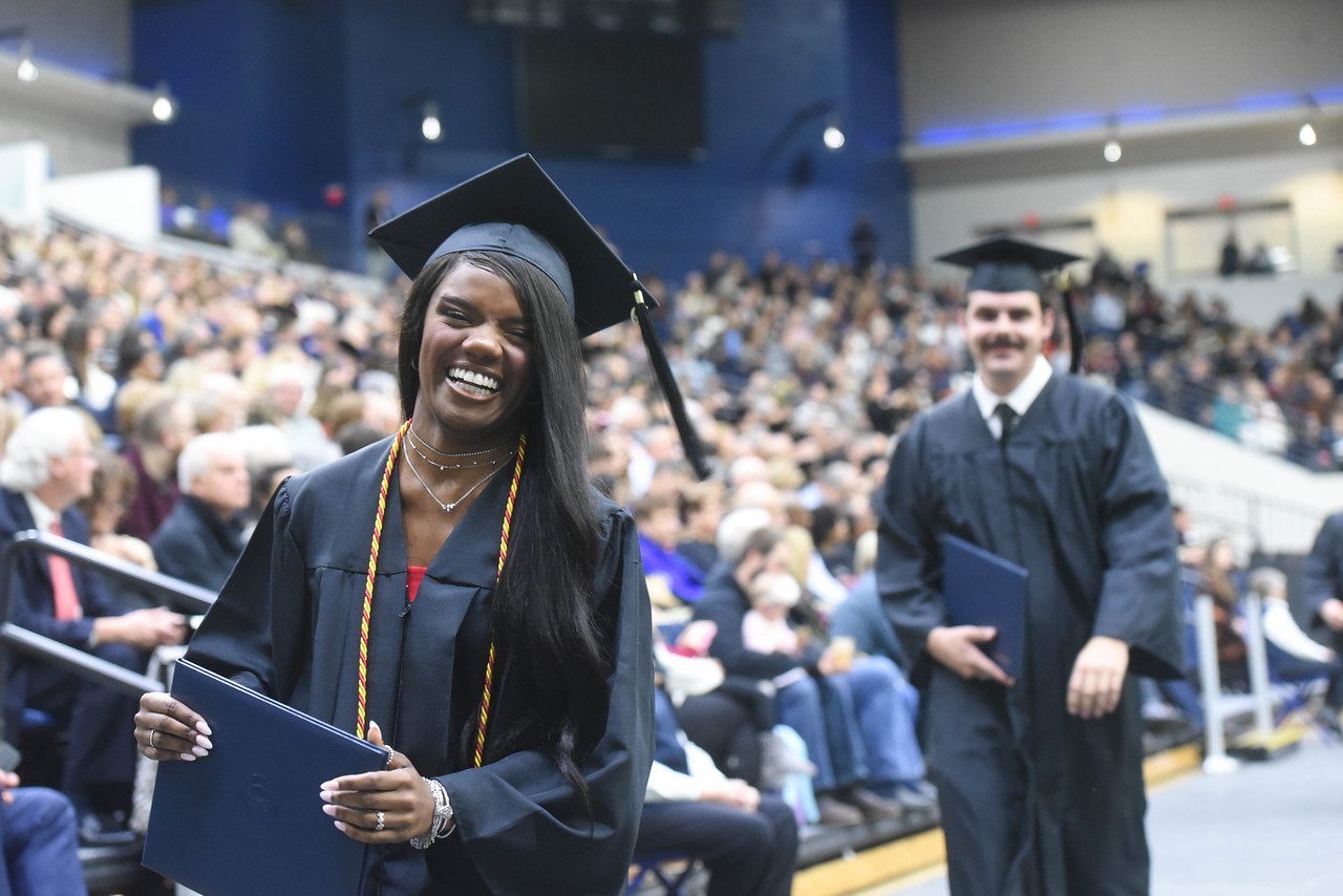 Graduates walking to seat after receiving diploma