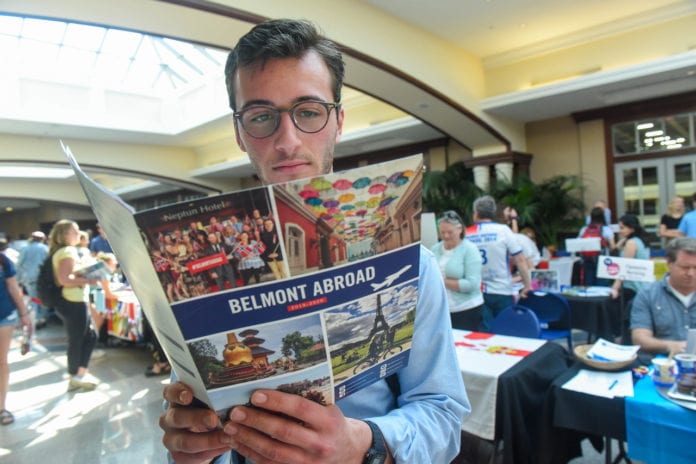 Student reads brochure at the Belmont Abroad Fair