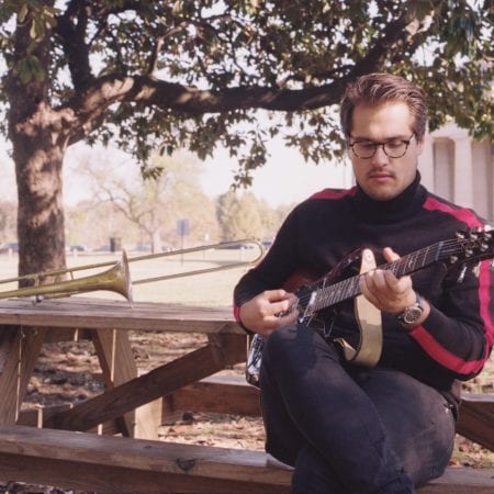 Collin Felter playing guitar at the park