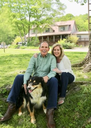 The Spencers pose with their dog in front of the Lodge