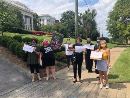 Belmont employees hold signs and bells