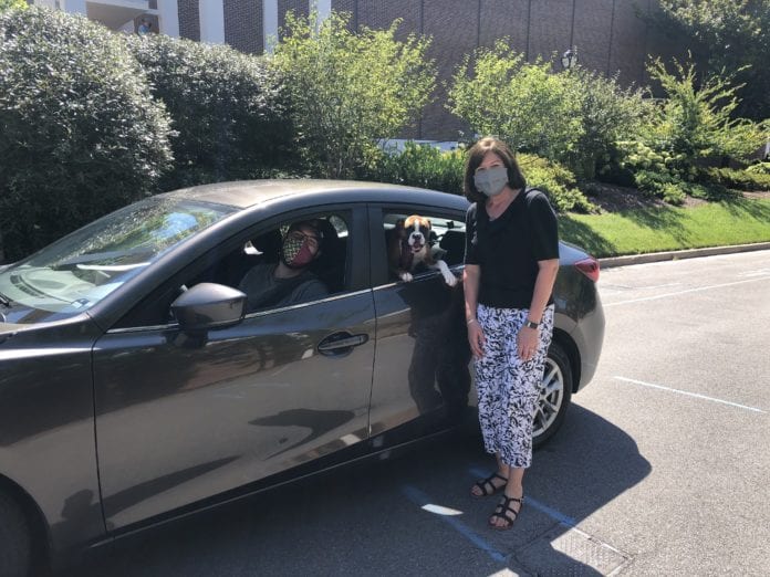 Powell stands with student veteran in a car