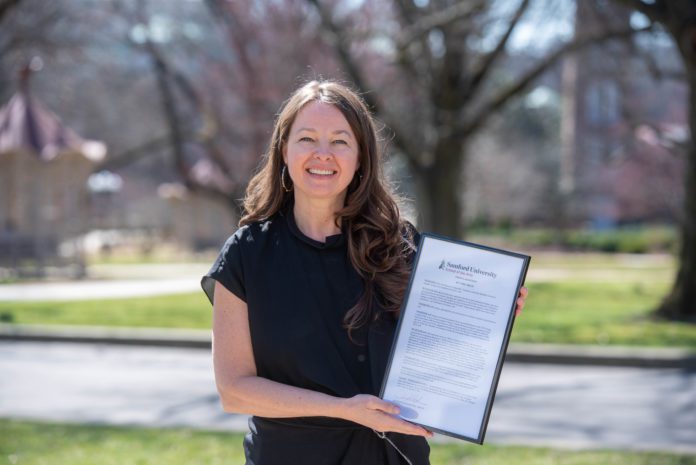 Jill Robinson holds award