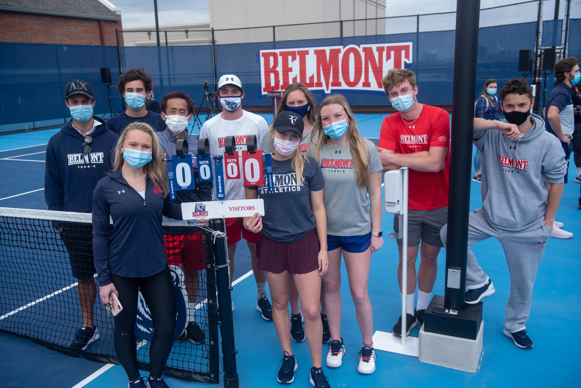 Tennis team members pose for a picture after a ribbon cutting ceremony opening Belmont's new rooftop tennis facility.