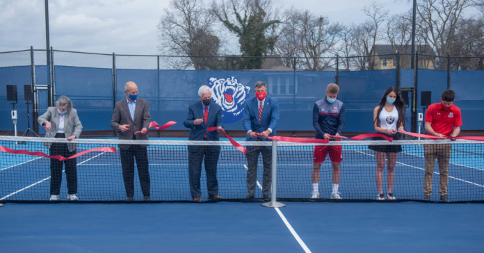 Pat Johnson, Bill DeLoache, Dr. Fisher, Scott Corley, Marko Illic, Somer Henry and Mauricio Antun cut the ribbon during the ceremony opening Belmont's new rooftop tennis facility at Belmont University in Nashville, Tennessee, March 10, 2021. rrThe court are on top of a parking garage and directly next to the new Athletic facility that will be opening soon.
