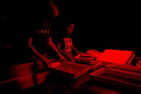 Students in Dark Room processing photographs