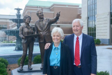 Judy and Bob Fisher stand in front of the sculpture presented in their honor
