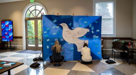 Kiosk shown to the left with design elements from "Agents of Hope" Mural, pictured with Dove Mural