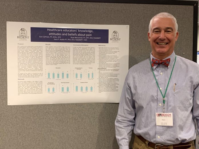 Dr. Austin stands before his research poster at the Annual Conference.