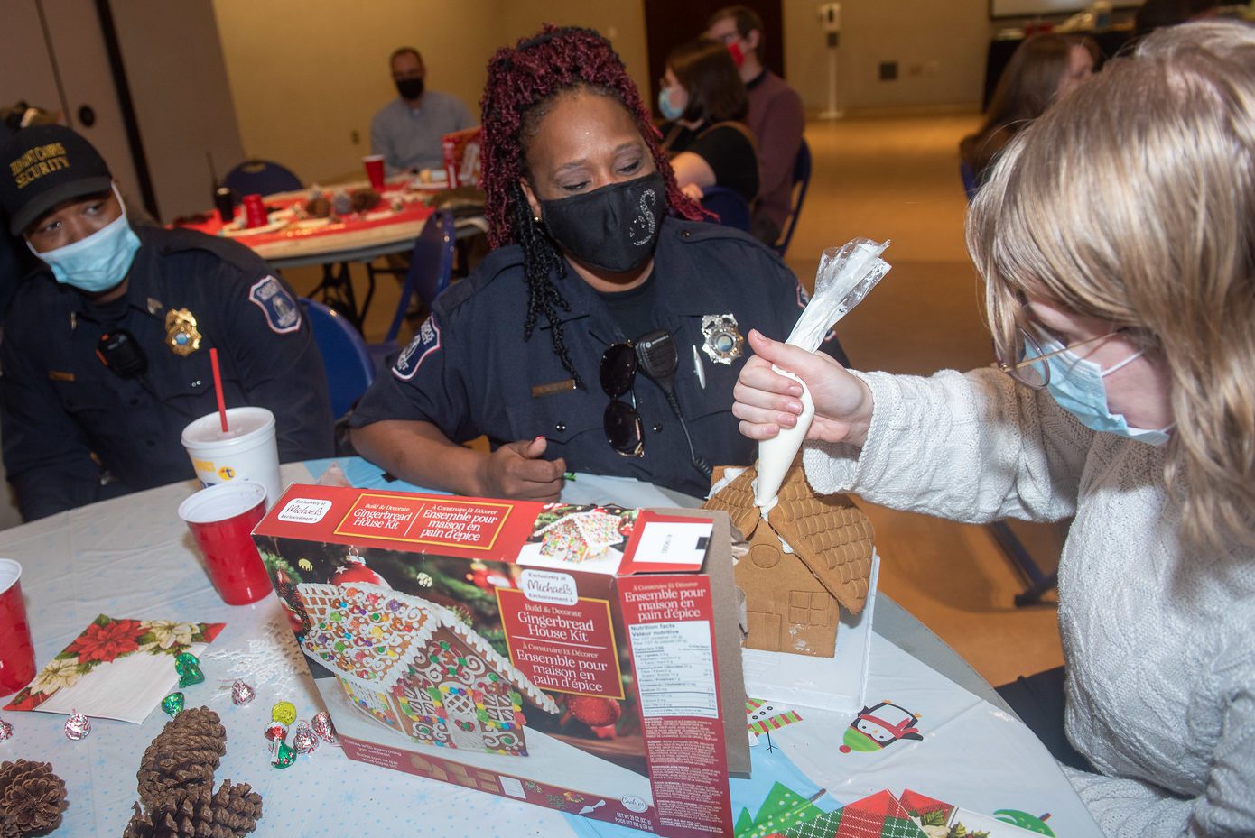 security officers decorate gingerbread house